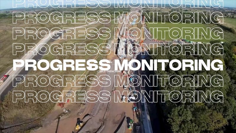 Aerial video frame showing highway construction progress monitoring and cable trenching works on a new road.