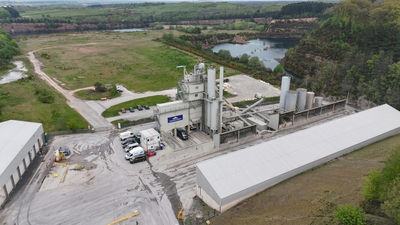 High-angle drone photograph showing an industrial asphalt plant and depot within a rural quarry landscape.