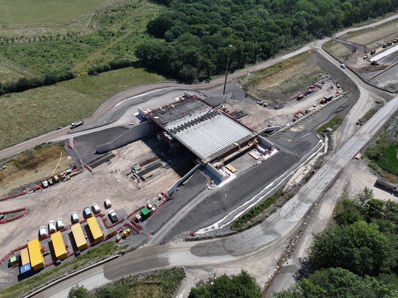 Aerial drone shot of a bridge structure under construction with a site compound and temporary access roads.